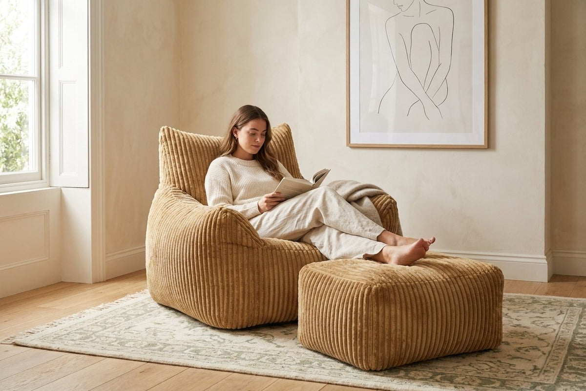 Lecture dans le fauteuil pouf Pola caramel, pieds sur l'ottoman