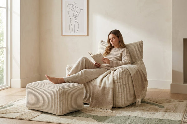 Lecture dans le fauteuil pouf Pola blanc crème, pieds sur l'ottoman